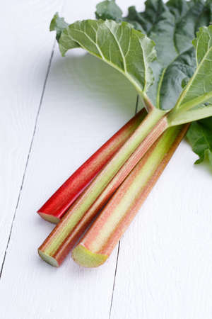 Bundle of rhubarb on white wooden table.の写真素材