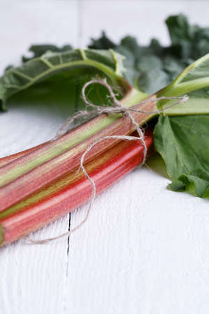 Bundle of rhubarb on white wooden table.の写真素材