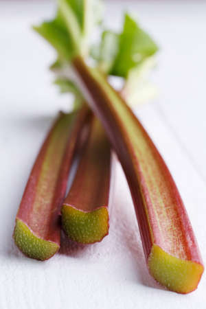 Bundle of rhubarb on white wooden table.の写真素材