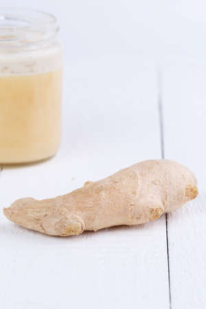 Fresh ginger on white wooden table.の写真素材
