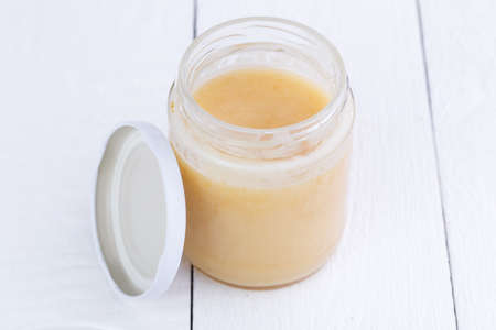 Jar of honey on white wooden table.の写真素材