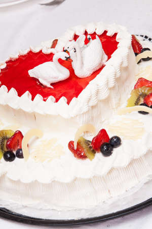 Delicious wedding cake with swans and fruits.の写真素材