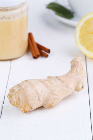 Fresh ginger with cinnamon, honey jar, and green tea.の写真素材