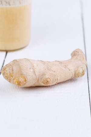 Fresh ginger on white wooden table.の写真素材