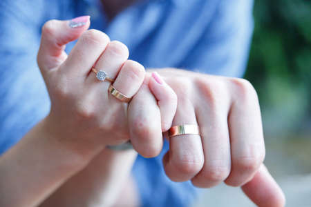 Married couple holding hands with wedding rings.の写真素材