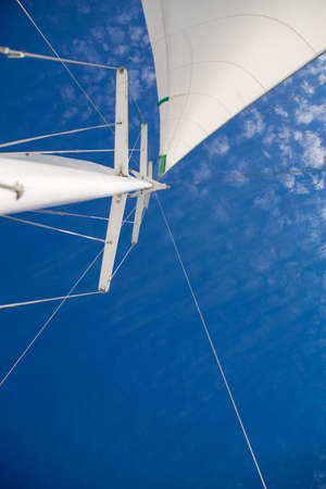 Mast and sail against the sky with clouds.
