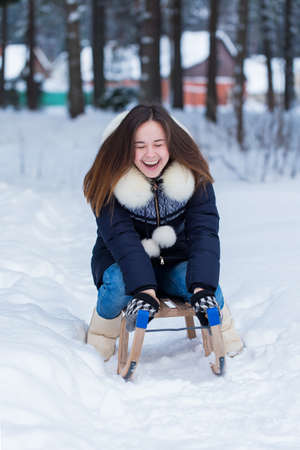 Winter fun of young woman on sleds.の写真素材