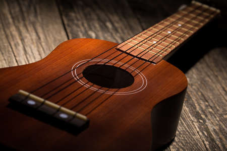 Close up of ukulele on old wood background.