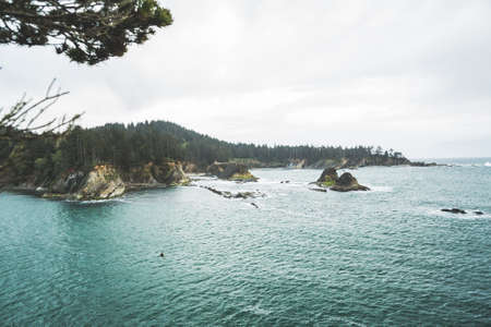 Landscape of Pacific ocean beach and hills.