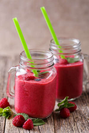 Healthy raspberry smoothie with mint leaves and drinking straw.の写真素材