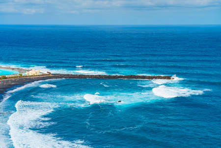 Breakwater of beach with black sand. Playa de Martianez, Puerto de la Cruz, Tenerife, Spain.