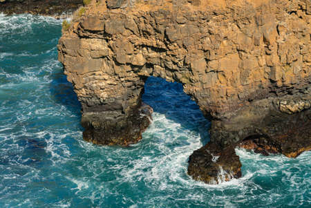 Wave breaking on the rocks in the sea, grotto rock. Oceanic shore rocky formations. Tenerife, Spain.の写真素材