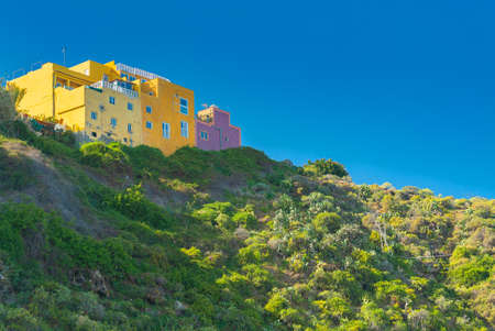 View on mountain and colorful buildings on the top in Punta Brava, Puerto de la Cruz, Tenerife, Canary Islands, Spain.の写真素材