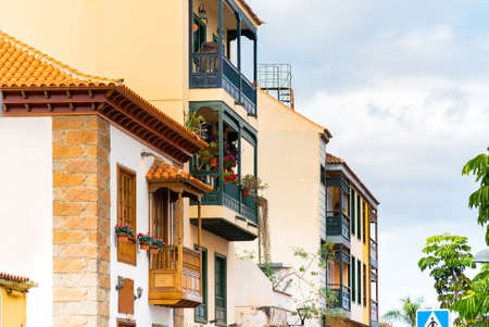 Colorful buildings with a wooden balconies on a street in spanish town Puerto de la Cruz on a sunny day, Tenerife, Canary islands, Spainの写真素材