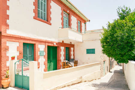 Sunny narrow street in old village Omodos on Cyprus. Stone walls and vibrant green plants on a sunny dayの写真素材