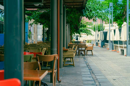 Chairs and tables in an outdoor cafe on a narrow street in Limassol, Cyprus. Nobody
