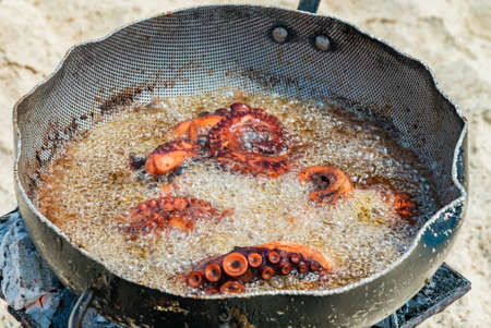 Ocotopus boil in oil on a sandy beach. Picnic on a beach in Zanzibar, Tanzania.の写真素材
