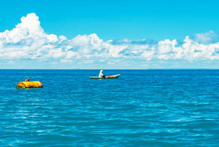 Fishing boat with a woman in water of Indian ocean. Zanzibar, Tanzania.の写真素材