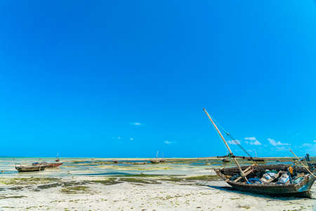 Close up of boat on a beach during large low tide in Nungwi Zanzibar, Tanzania.の写真素材