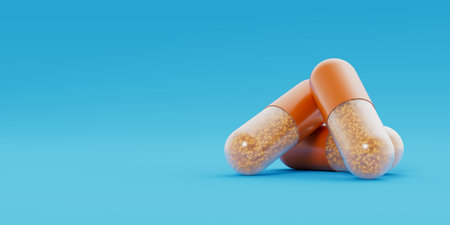 Three orange transparent capsules, pills with orange granules inside lay on blue background. Medicinal treatment, tablet, cure concept. Place for text. 3d render illustrationの写真素材