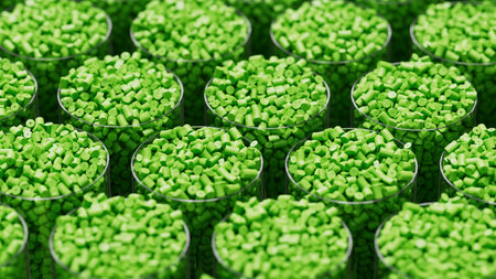 Grid of glasses filled with green plastic polypropylene granules, masterbatch polymer grain, with...