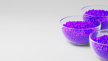 Glass cups with purple plastic polypropylene granules, masterbatch polymer grain, on white backdrop....