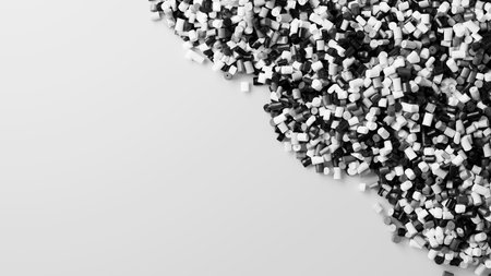 Closeup top view on black and dark white plastic polypropylene granules heap on white backdrop,...