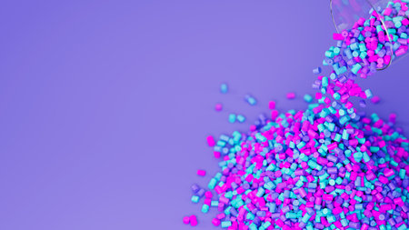 Top view of colorful plastic polypropylene granules pouring from the glass on a violet backdrop,...