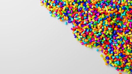 Closeup top view on colorful plastic polypropylene granules heap on white backdrop, masterbatch...