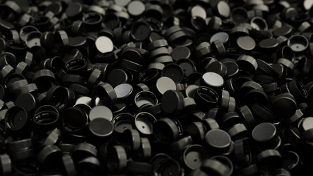 Side view on a pile of black plastic bottle caps with shallow DOF. Plastic industry product. Garbage...