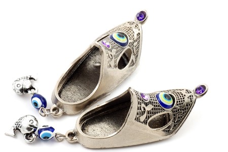 Slippers a souvenir from metal close up on a white background