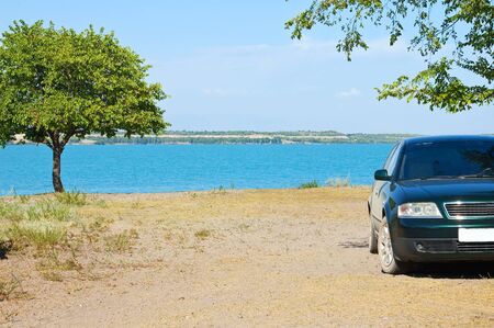 The car ashore under the bright summer sunの写真素材