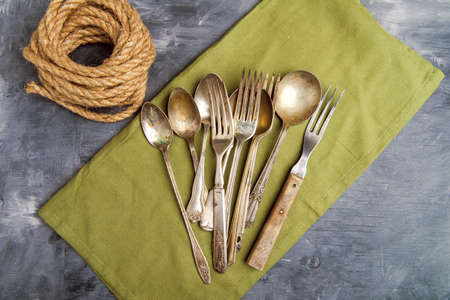 vintage cutlery on a napkin. view from above. Forks, spoons on a gray table