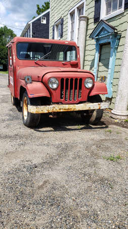Leesburg. Virginia. USA. May 2, 2021 an old red post jeep is parked in front of an old building....