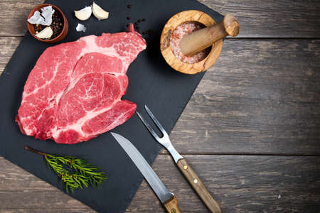 fresh meat, salt, pepper and garlic on a black stone board. View from above.space for textの写真素材