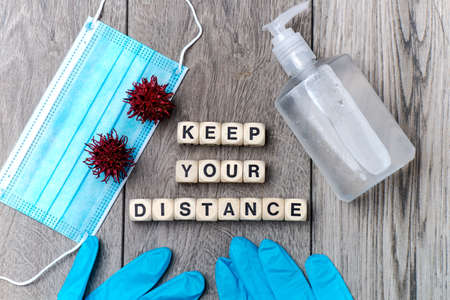 face shield, gloves and disinfectant. inscription from cubes - KEEP YOUR DISTANCE.