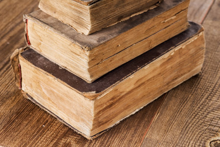 stack of three vintage shabby books on an old wooden table.macro. selective focus.の写真素材