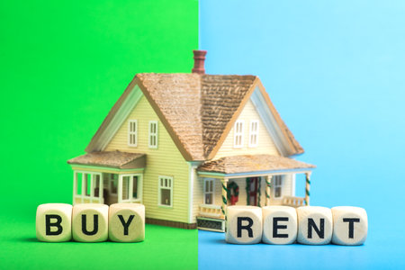 Buy or rent a house. Concept from a house model and wooden cubes.の写真素材