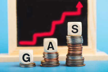 Rising fuel prices. The inscription GAZ on the stacks of coins symbolizes the graph of the growth of...