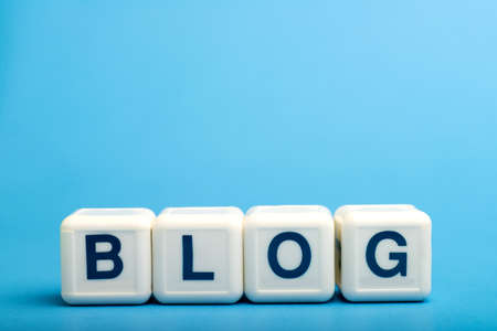 Blog. Word from letters on wooden cubes. On blue background. Space for text
