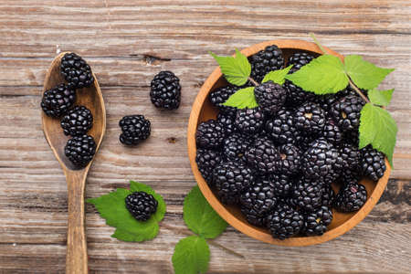 fresh blackberries in a wooden plate and spoon. view from above. Space for text.の写真素材