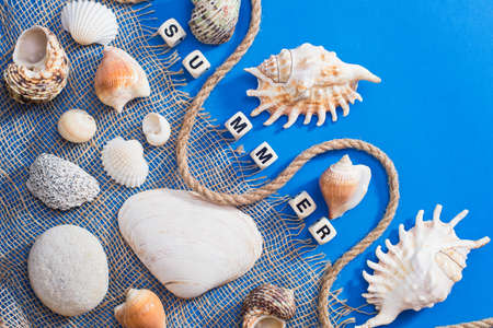 vacation and travel concept. Seashells, rope and the inscription SUMMER made of cubes. Background...