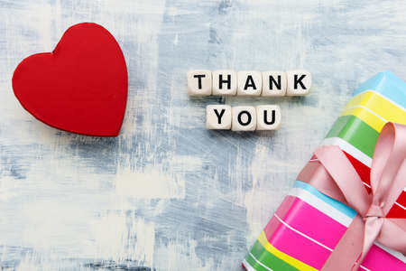 Red heart, gift box and inscription from wooden cubes THANK YOU. Space for text. view from above.の写真素材