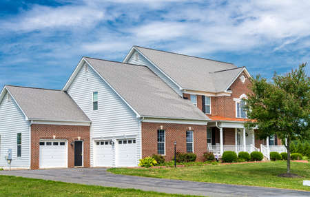 Country house in the suburbs of Leesburg, Virginia with a green lawn in the foreground. Blue sky, clear summer day.のeditorial素材