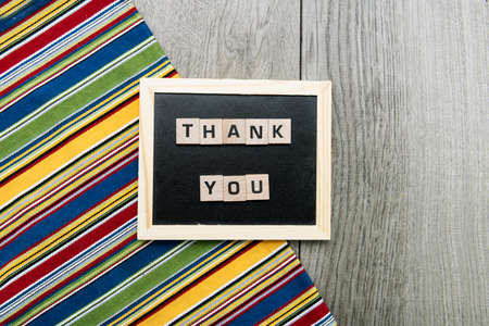 Wooden cubes with thank you lettering on the blackboard. view from above.の写真素材