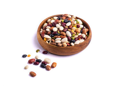 many dried multi-colored beans closeup, an assortment of various kidney beans and peas on a white...