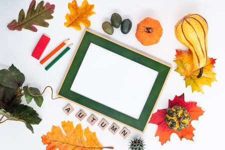 Autumn composition of fallen leaves, pumpkins and frame for text. the word AUTUMN is composed of wooden cubes. view from above. Flat lay with copy space.の写真素材