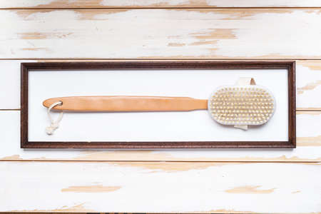 Natural shower brush with wooden handle in a portrait frame.の写真素材
