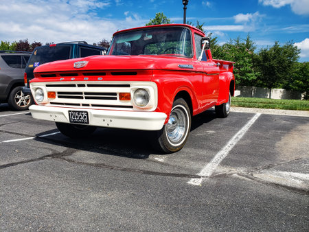 red classic 1955 Ford F-100 Pickup Truck. Parked in a parking lot next to an apartment building.のeditorial素材