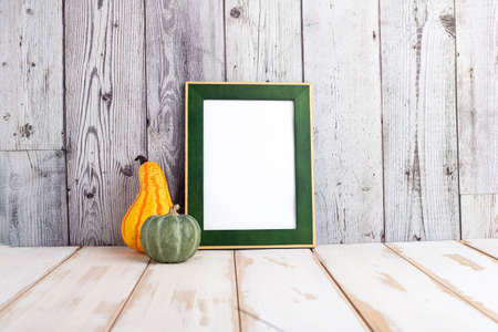 Autumn and Halloween concept. Portrait frame against a light wall. Frame with pumpkins and space for text.の写真素材